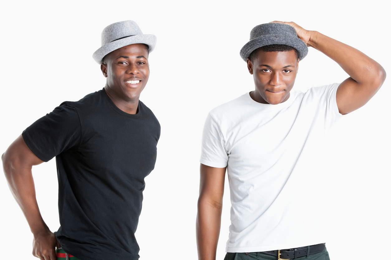 Portrait of happy young african american men wearing hats over gray background